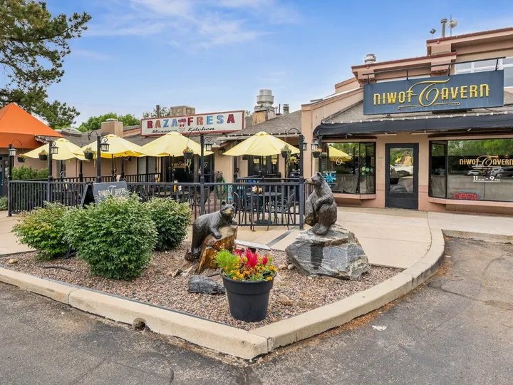The covered patio outside Niwot Tavern, with the bear sculptures on the corner of Cottonwood Square
